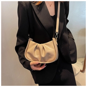 Détail du sac nuage plissé beige clair avec finitions dorées et texture cuir raffinée