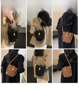 Detail view of leather bucket bags showing top handle and adjustable shoulder strap modes