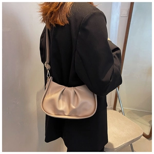 Détail du sac nuage plissé abricot avec texture cuir et fine bandoulière réglable