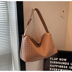 Détail du sac hobo camel à texture tressée suspendu avec large bandoulière