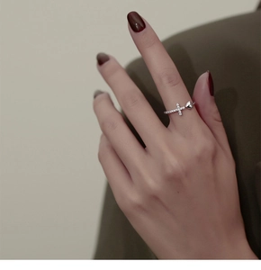 Détail de la bague ajustable avec cœur poli et croix sertie de zircons brillants