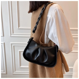 Détail du sac à bandoulière plissé noir avec boucles dorées et sangle tressée