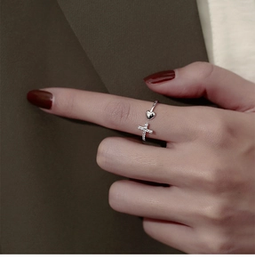 Gros plan d'une bague ouverte en argent avec cœur et croix en zircons sur un mannequin