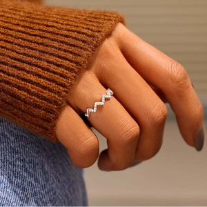 Close-up of a silver zigzag wave ring with pavé pavé-set diamonds on a hand
