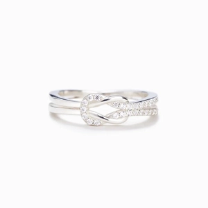 Macro detail of silver knot ring with pave-set white crystals on double-layered band