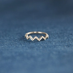 Detailed macro shot of the golden wave V-shaped ring with pavé diamond stones