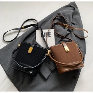 Detail of vintage bucket bags in black and brown with suede paneling and gold twist locks