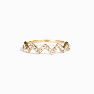 Macro detail of V-shaped wavy gold ring with pavé set white crystals for women