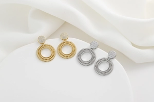 Detailed view of gold and silver sunwheel drop earrings with pavé micro zircons