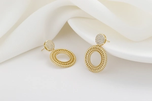 Macro detail of gold round stud earrings with pavé zircon and beaded radiant texture