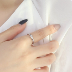 Primo piano di un anello a nodo in argento con zirconi brillanti indossato da una donna