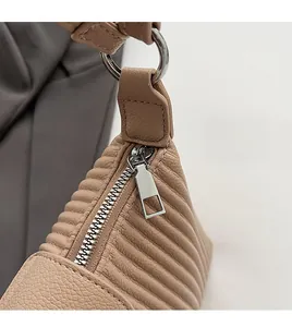 Détail du zip argenté lisse et de la texture en cuir à rayures verticales du sac