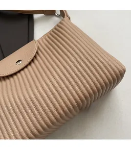 Gros plan sur un sac fourre-tout kaki avec plis verticaux et texture en cuir grainé