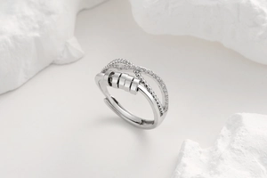 Close-up of rotatable spinner ring with zircon stones and four sliding beads on white stone