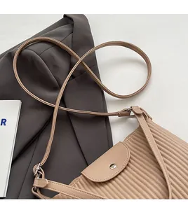 Vue détaillée du sac bandoulière beige plissé avec texture fine et fermoir magnétique