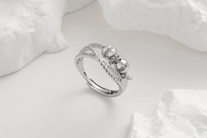 Detail of silver open ring featuring pavé diamond spheres and twisted rope band texture