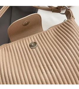 Vue détaillée de la boucle magnétique argentée sur un sac en cuir plissé marron clair