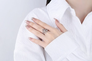 Detail of silver crisscross ring with micro-pave diamonds worn on index finger