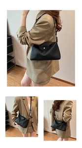 Détails de la texture plissée verticale noire et boucle argentée du sac à bandoulière