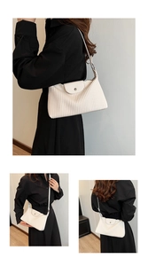 Détail d'un sac à bandoulière blanc plissé avec boucle en métal porté par un mannequin