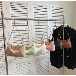 Gros plan de sacs à bandoulière plissés en six couleurs sur un présentoir