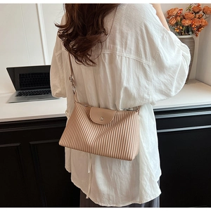 Détail du sac cabas plissé beige en cuir avec texture verticale et boucle métallique