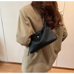 Détail d'un sac porté épaule plissé noir en cuir avec une boucle métallique argentée élégante
