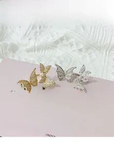 Macro detail of gold and silver butterfly rings with sparkling zircon pavé settings