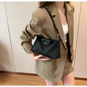 Gros plan sur le sac baguette noir plissé en similicuir avec boucle ronde en métal argenté