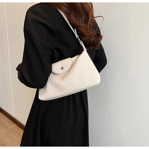 Vue détaillée du sac bandoulière plissé blanc cassé avec boucle magnétique sur modèle