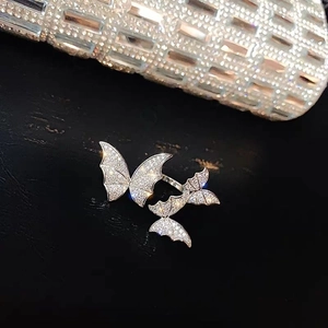 Macro shot of silver butterfly rings with micro-pave white zircon on black leather