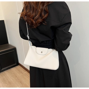 Détail du sac à bandoulière blanc à plis verticaux fins et fermoir métallique élégant