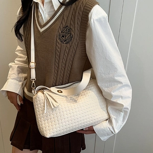 Sac bandoulière blanc à texture tressée avec boucle dorée et pompon au style décontracté