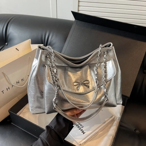 Silver metallic tote bag with bow detail and chain strap in a stylish gift box
