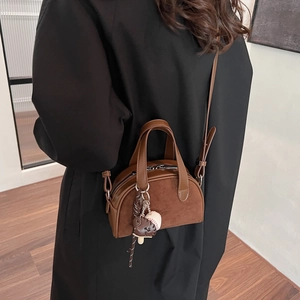 Detail of brown vintage matte leather mini handbag with ice cream and baseball charms