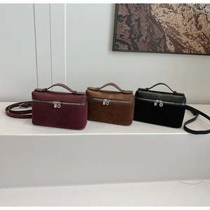 Detailed view of three crossbody bags in purple, brown, and black with double zippers