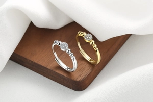Close-up of gold and silver adjustable rings with pavé zircon and beaded details