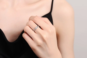 Close-up of elegant silver bubble ring with zircon cluster on woman's index finger