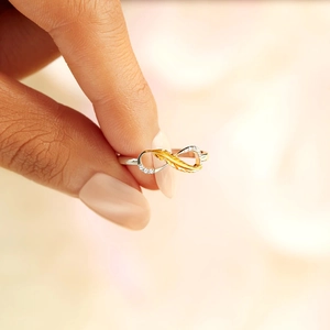 Elegant S925 silver infinity ring featuring gold feather design and cubic zirconia