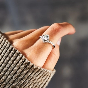 Elegant V-shaped moissanite crown ring with round cut center stone on female finger