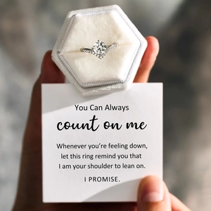 V-shaped moissanite crown ring with small diamonds held in a white velvet gift box
