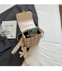 Détail du sac boîte beige matelassé montrant l'espace intérieur pour téléphone