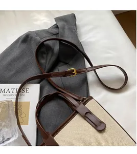 Close-up of canvas weave and brown leather stitching on a retro bucket bag