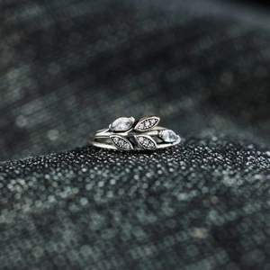 Minimalist S925 sterling silver leaf ring featuring marquise-cut stones on a grey fabric background