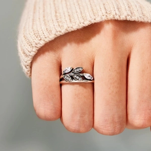 Vintage leaf open ring with marquise zircon stones shown on finger with soft knit background