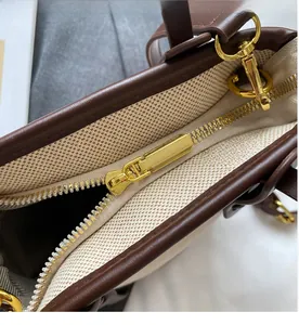 Detailed close-up of smooth gold metal zipper and stitching on the contrast bucket bag