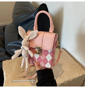 Détail du mini sac à bandoulière matelassé rose avec charm lapin et fermoir doré
