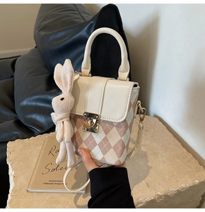 Détail de la sacoche rose à motif losanges avec un charmant lapin décoratif rose