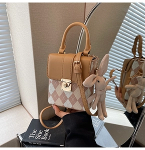 Détail du mini sac bandoulière matelassé avec un pendentif lapin en peluche et fermoir doré