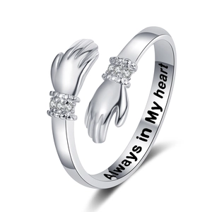 Macro view of hugging hands ring with sparkling zircon and Always in My Heart engraving